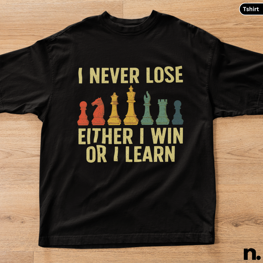 Black t-shirt with chess piece graphics and text on a wooden surface