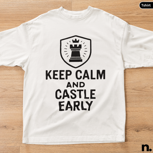 White t-shirt with a black chess-themed design on a wooden surface