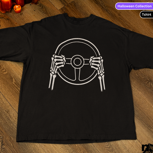 Black t-shirt with white graphic of hands on a steering wheel on a wooden surface.