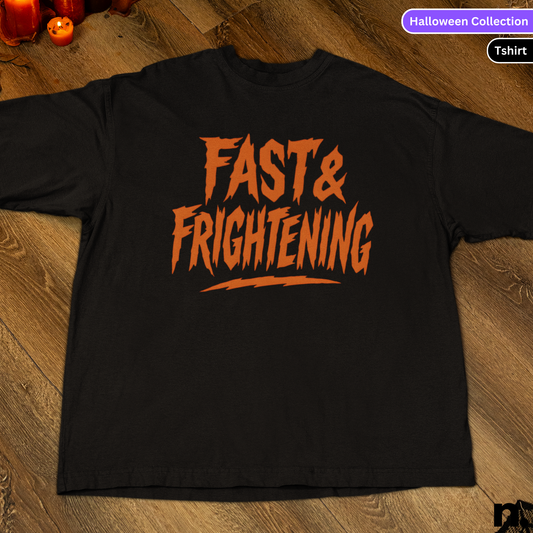 Black t-shirt with 'Fast & Frightening' text in orange on a wooden surface.