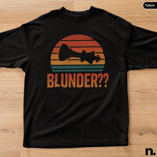 Black t-shirt with a graphic design and text 'BLUNDER??' on a wooden surface