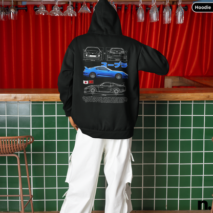 Person wearing a black hoodie with car designs on the back, standing in a bar setting.