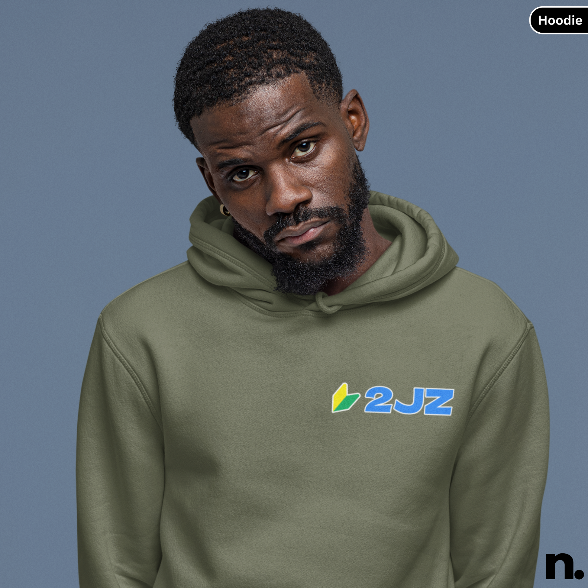 Man wearing a green hoodie with '2JZ' logo against a blue background