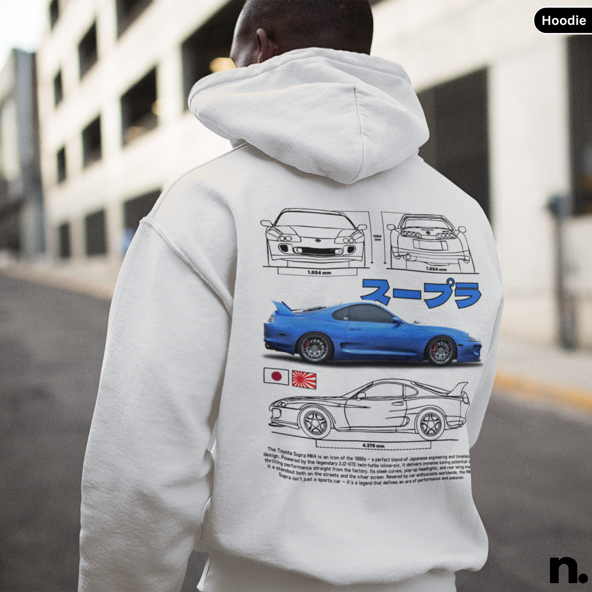Person wearing a hoodie with car graphics on the back, standing in an urban setting.
