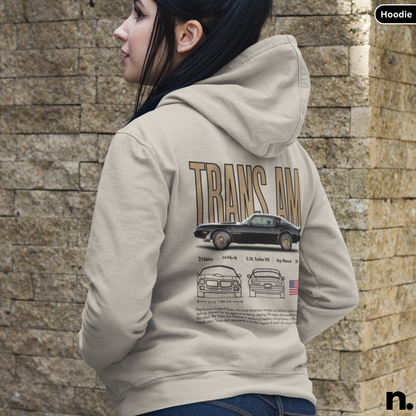 Person wearing a hoodie with 'Trans Am' design on the back against a stone wall.