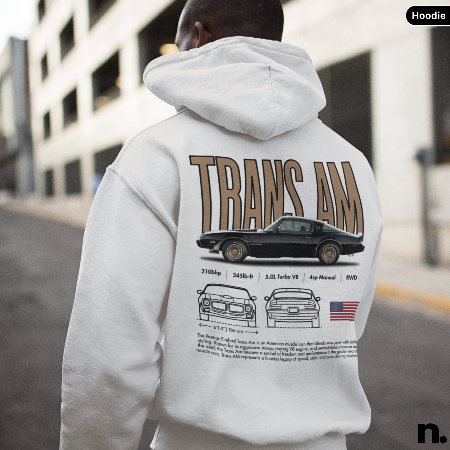 Person wearing a hoodie with 'TRANS AM' design on the back, standing in an urban setting.