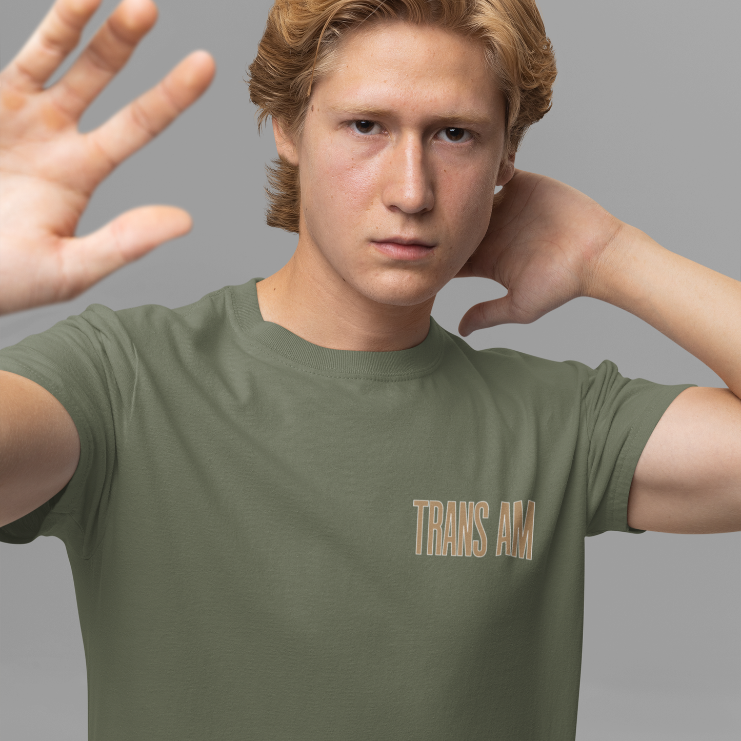 Person wearing a green t-shirt with 'TRANS AM' text on a gray background
