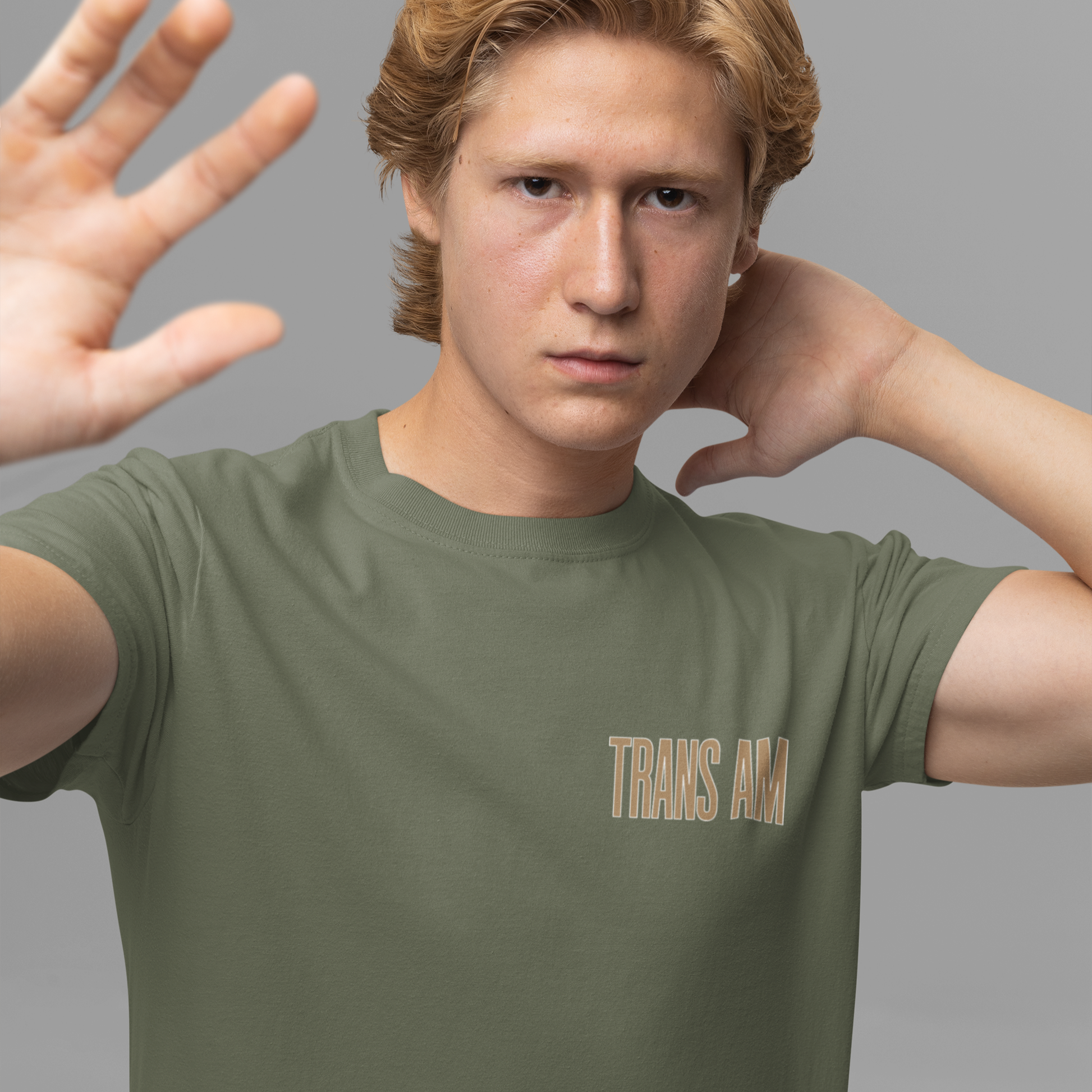Person wearing a green t-shirt with 'TRANS AM' text on a gray background