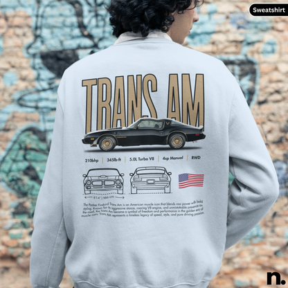 Person wearing a sweatshirt with a graphic of a car and text on the back, against a graffiti-covered wall.