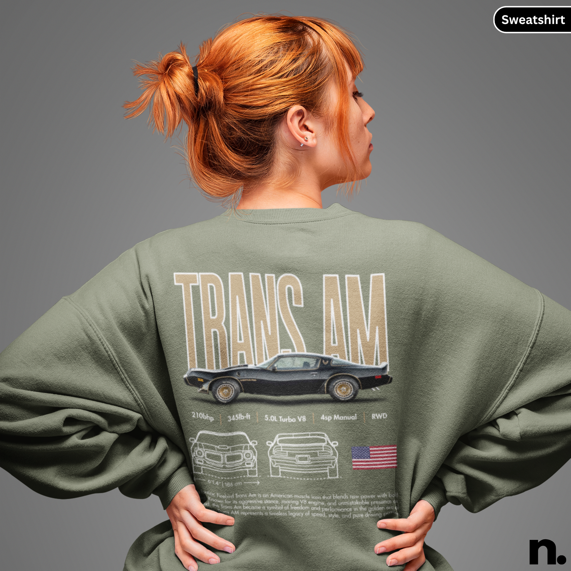 Person wearing a green sweatshirt with 'TRANS AM' design on the back, standing against a gray background.
