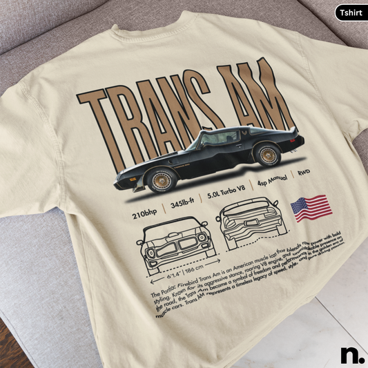 Beige t-shirt with a graphic of a car and 'TRANS AM' text on a gray surface.