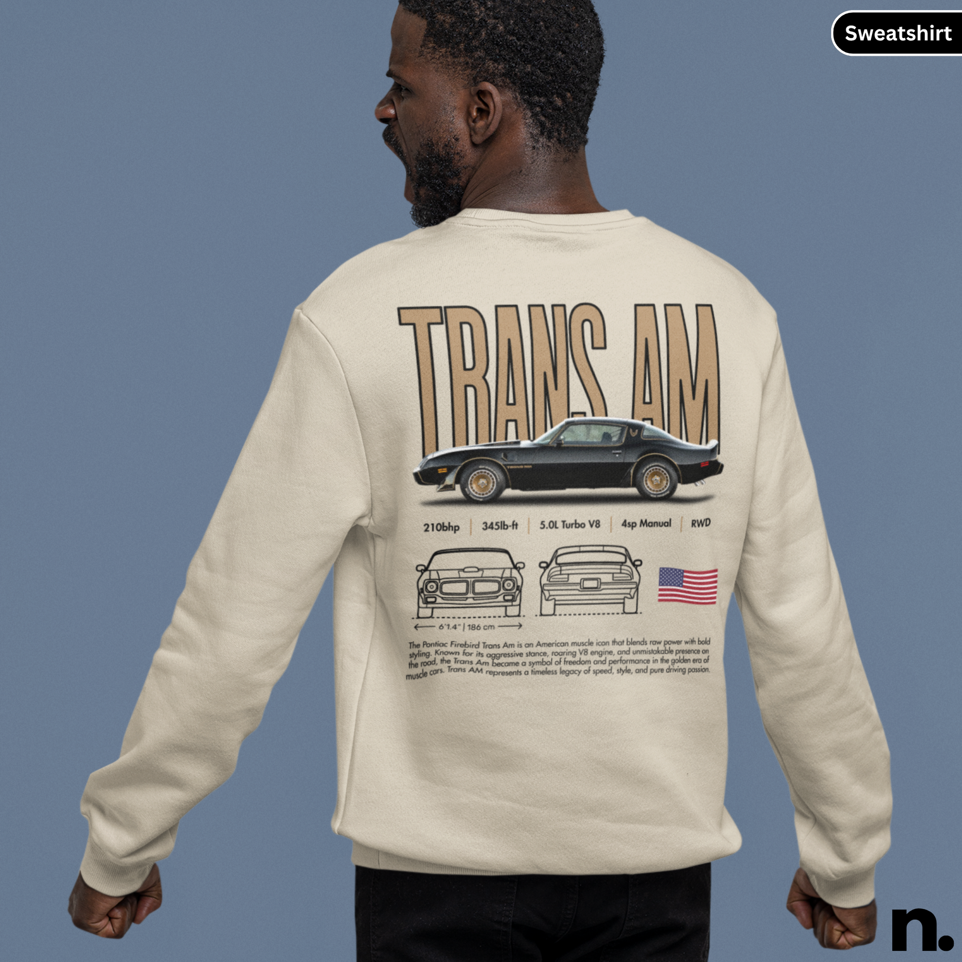 Person wearing a beige sweatshirt with 'TRANS AM' design on the back against a blue background