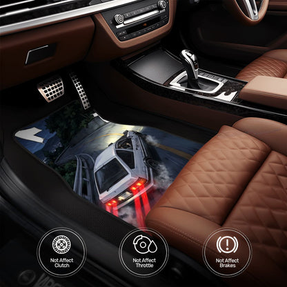Car interior with a floor mat featuring a graphic of a car on a road.